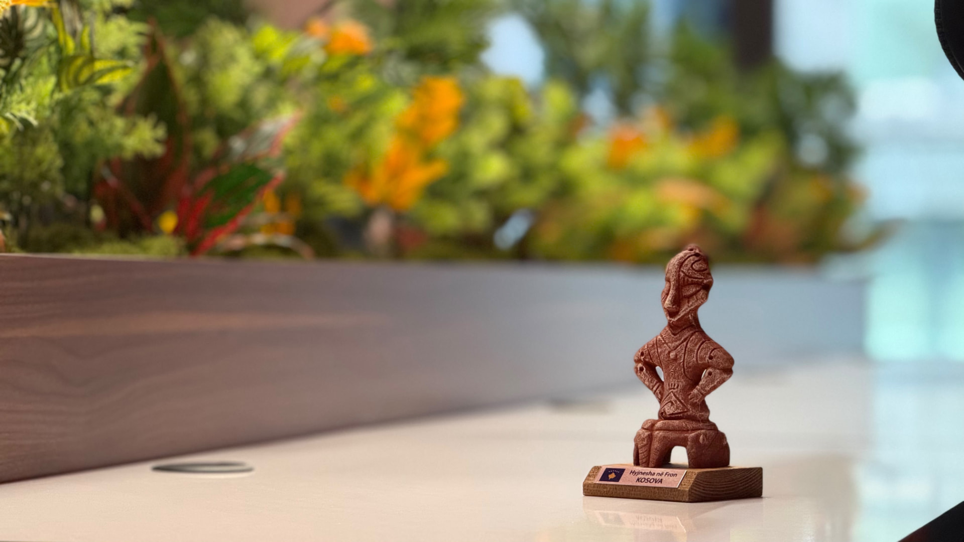 Handmade Kosova figurine on a dedicated desk at PRN CO-WORK, surrounded by greenery